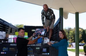 Indianapolis Colts kicker Adam Vinatieri (left) helps Heroes Foundation Chairman and Co-Founder Vince Todd, Jr. and board member Kelly Canada deliver LEGO sets to pediatric cancer patients.